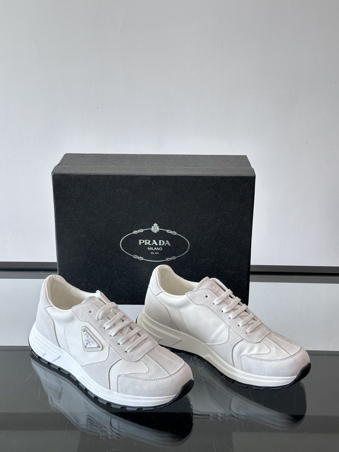 Prada 男士休闲运动鞋。采用麂皮与尼龙面料拼接，质感柔软又耐用，低调奢华。鞋侧三角徽标超有辨识度，橡