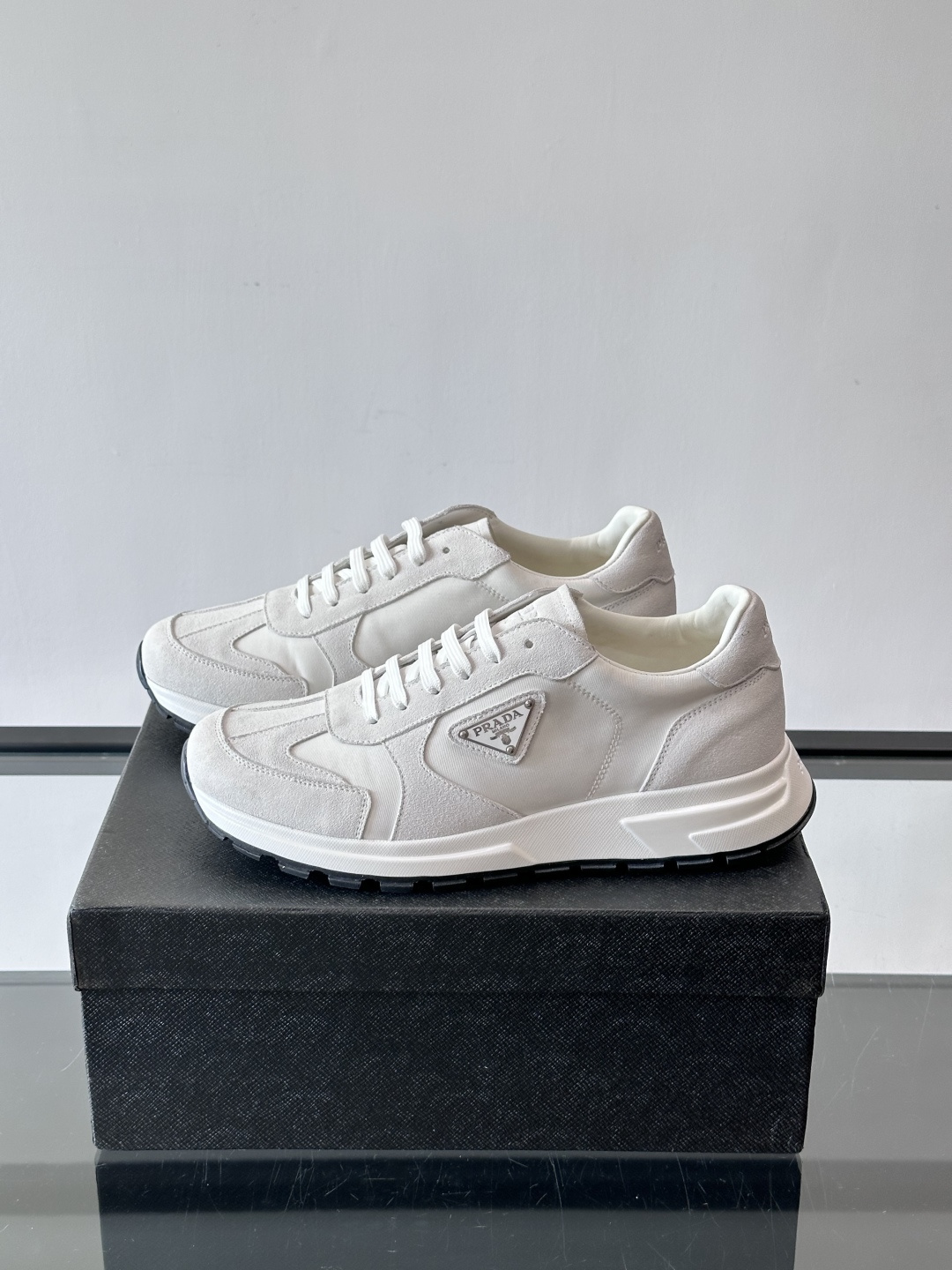Prada 男士休闲运动鞋。采用麂皮与尼龙面料拼接，质感柔软又耐用，低调奢华。鞋侧三角徽标超有辨识度，橡