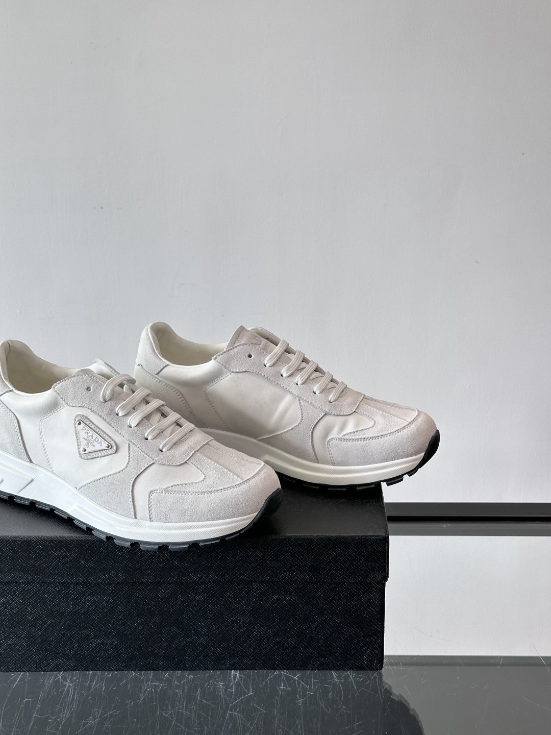 Prada 男士休闲运动鞋。采用麂皮与尼龙面料拼接，质感柔软又耐用，低调奢华。鞋侧三角徽标超有辨识度，橡