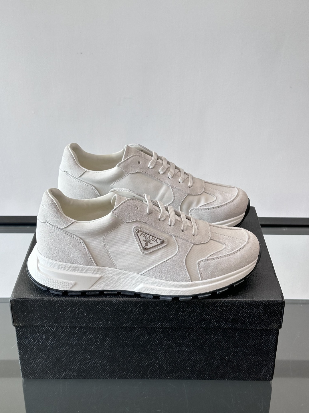 Prada 男士休闲运动鞋。采用麂皮与尼龙面料拼接，质感柔软又耐用，低调奢华。鞋侧三角徽标超有辨识度，橡