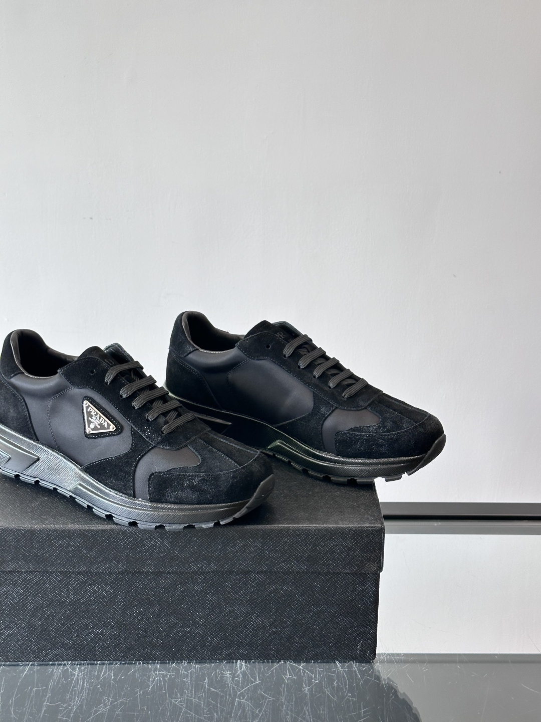 Prada 男士休闲运动鞋。采用麂皮与尼龙面料拼接，质感柔软又耐用，低调奢华。鞋侧三角徽标超有辨识度，橡