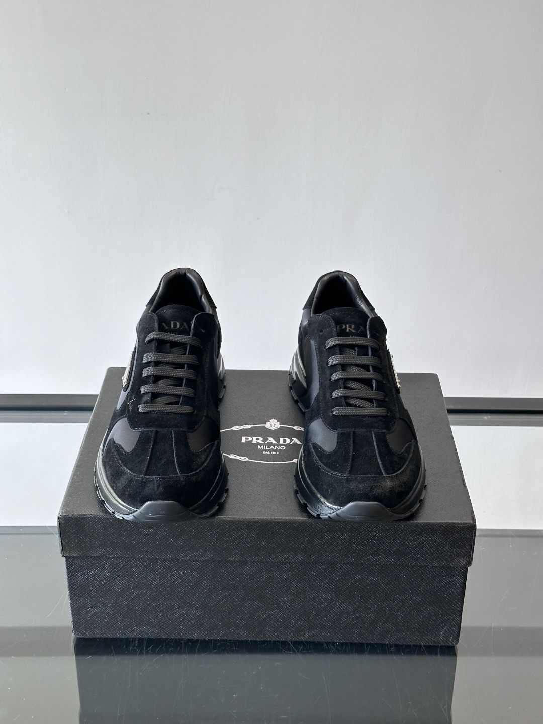 Prada 男士休闲运动鞋。采用麂皮与尼龙面料拼接，质感柔软又耐用，低调奢华。鞋侧三角徽标超有辨识度，橡