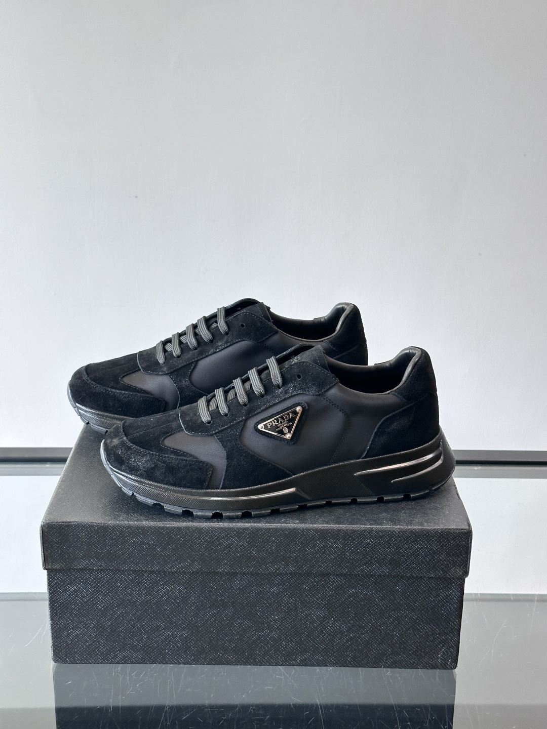 Prada 男士休闲运动鞋。采用麂皮与尼龙面料拼接，质感柔软又耐用，低调奢华。鞋侧三角徽标超有辨识度，橡