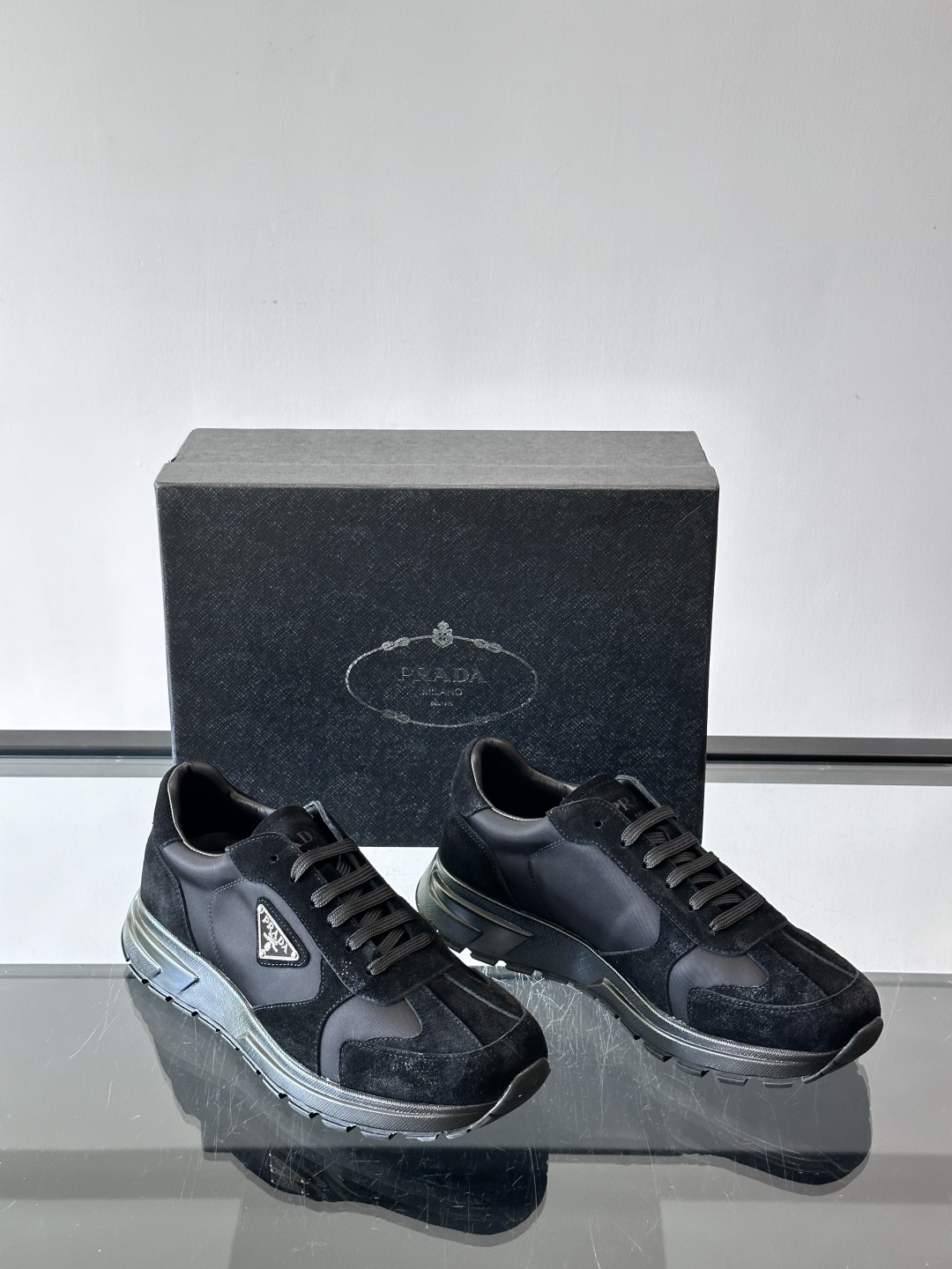 Prada 男士休闲运动鞋。采用麂皮与尼龙面料拼接，质感柔软又耐用，低调奢华。鞋侧三角徽标超有辨识度，橡