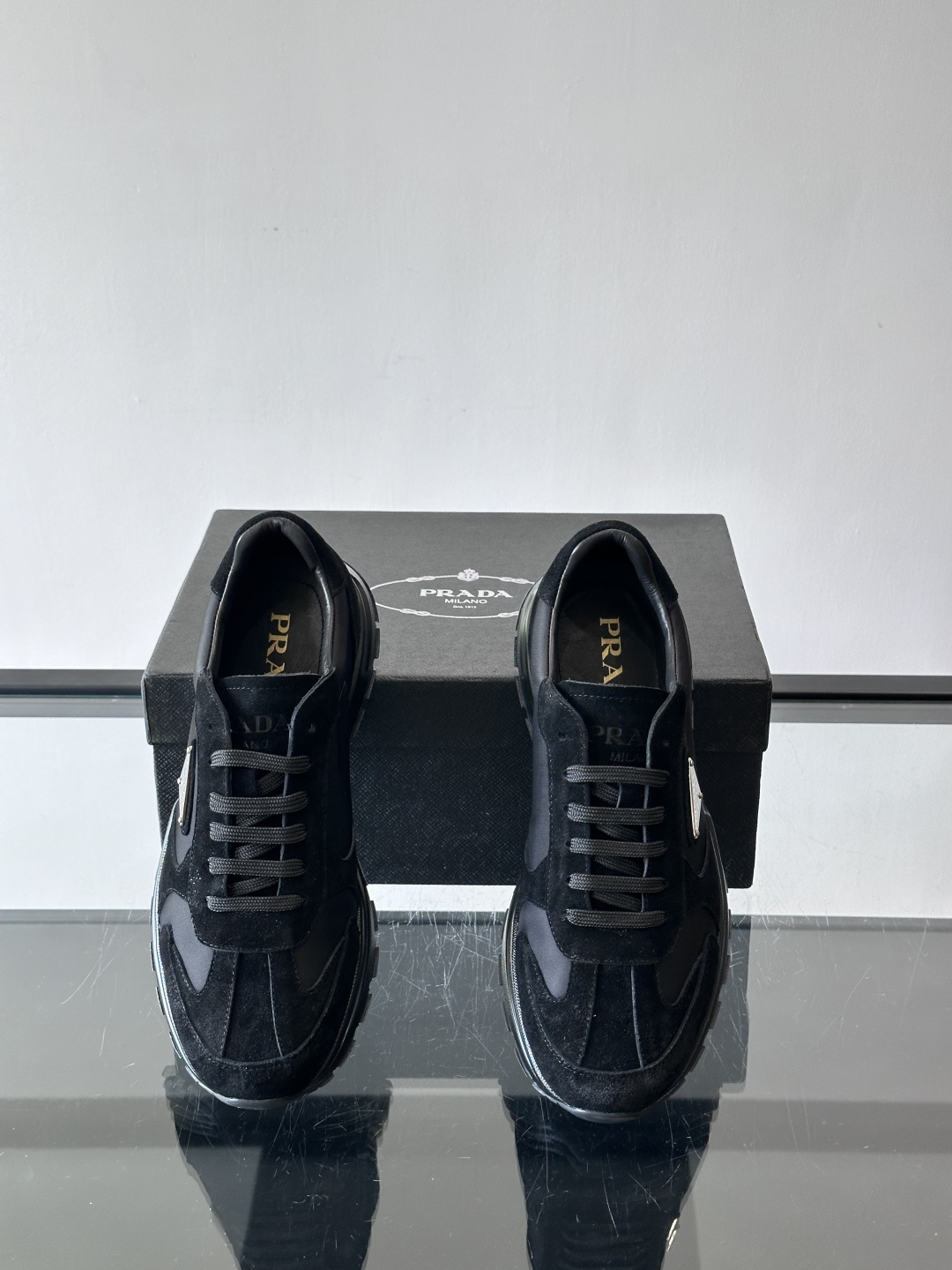 Prada 男士休闲运动鞋。采用麂皮与尼龙面料拼接，质感柔软又耐用，低调奢华。鞋侧三角徽标超有辨识度，橡