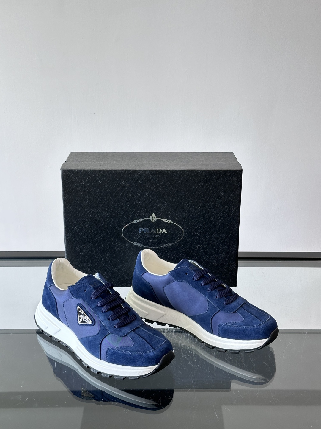 Prada 男士休闲运动鞋。采用麂皮与尼龙面料拼接，质感柔软又耐用，低调奢华。鞋侧三角徽标超有辨识度，橡