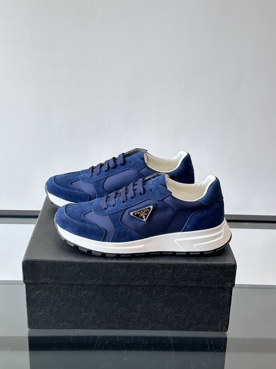 Prada 男士休闲运动鞋。采用麂皮与尼龙面料拼接，质感柔软又耐用，低调奢华。鞋侧三角徽标超有辨识度，橡