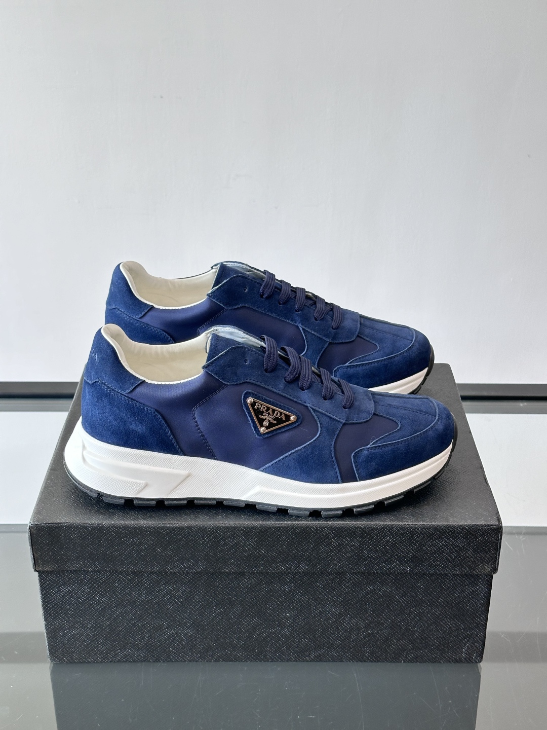 Prada 男士休闲运动鞋。采用麂皮与尼龙面料拼接，质感柔软又耐用，低调奢华。鞋侧三角徽标超有辨识度，橡