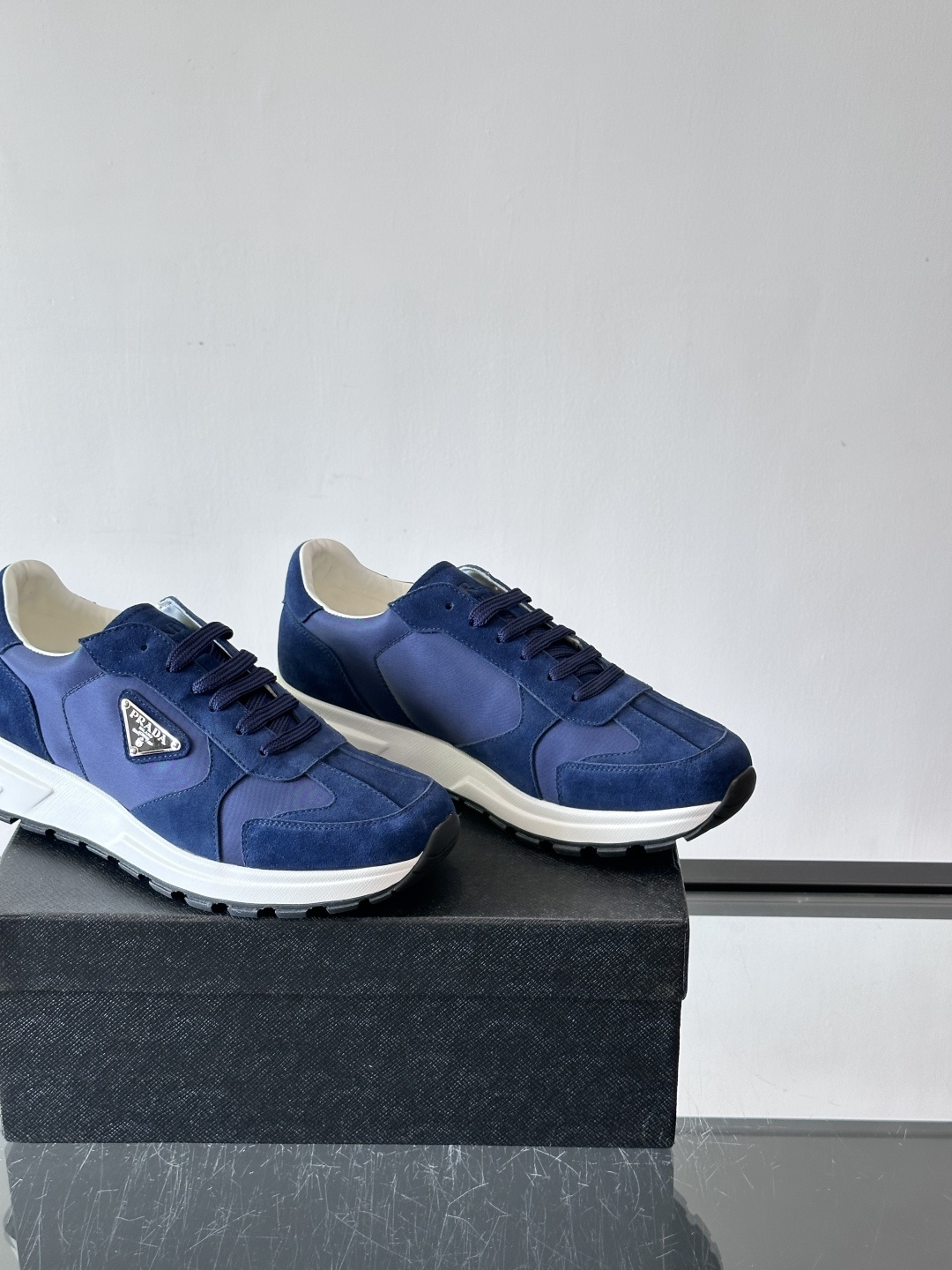 Prada 男士休闲运动鞋。采用麂皮与尼龙面料拼接，质感柔软又耐用，低调奢华。鞋侧三角徽标超有辨识度，橡