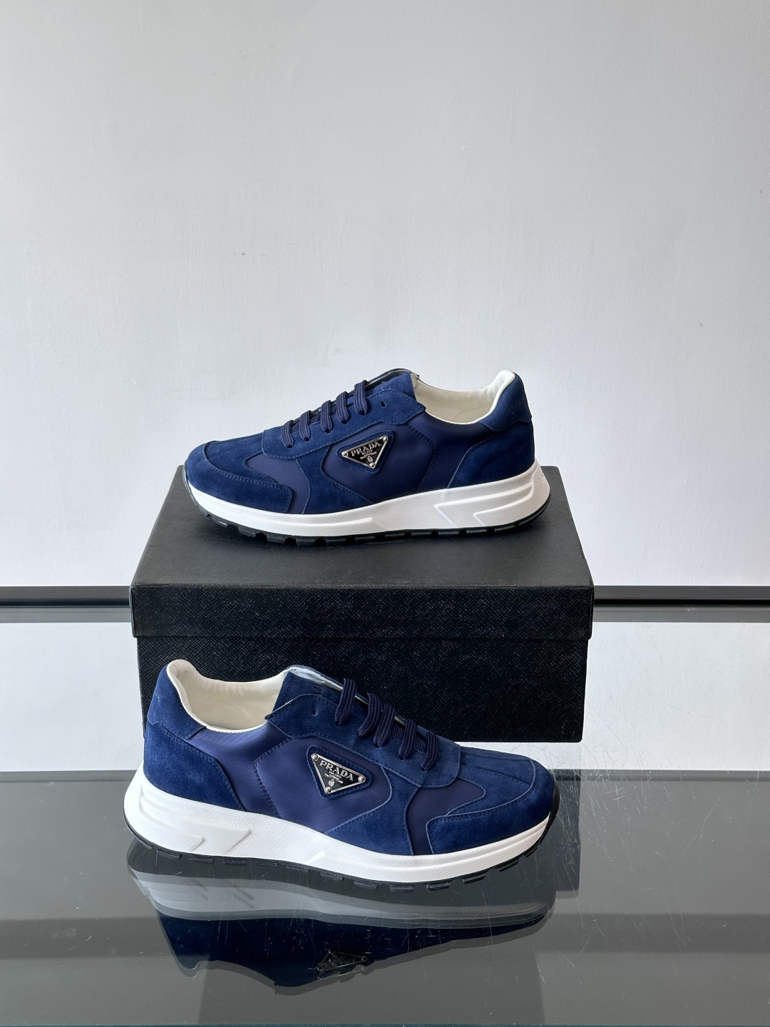 Prada 男士休闲运动鞋。采用麂皮与尼龙面料拼接，质感柔软又耐用，低调奢华。鞋侧三角徽标超有辨识度，橡