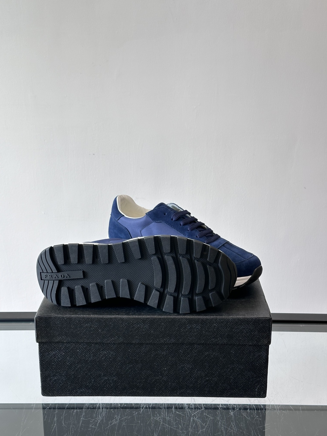 Prada 男士休闲运动鞋。采用麂皮与尼龙面料拼接，质感柔软又耐用，低调奢华。鞋侧三角徽标超有辨识度，橡