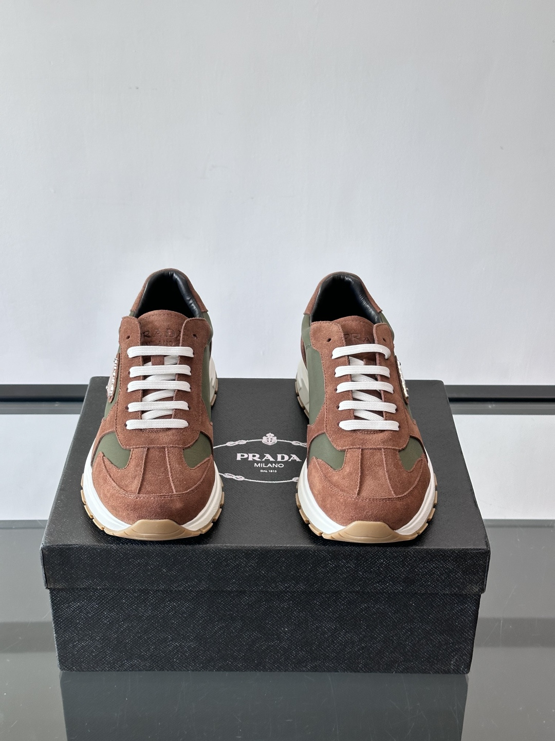 Prada 男士休闲运动鞋。采用麂皮与尼龙面料拼接，质感柔软又耐用，低调奢华。鞋侧三角徽标超有辨识度，橡