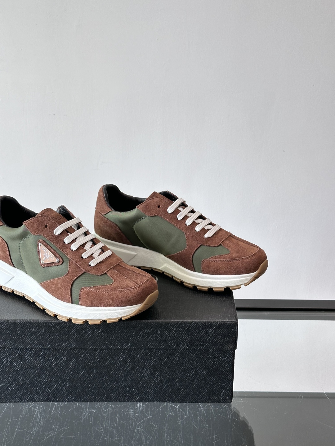 Prada 男士休闲运动鞋。采用麂皮与尼龙面料拼接，质感柔软又耐用，低调奢华。鞋侧三角徽标超有辨识度，橡