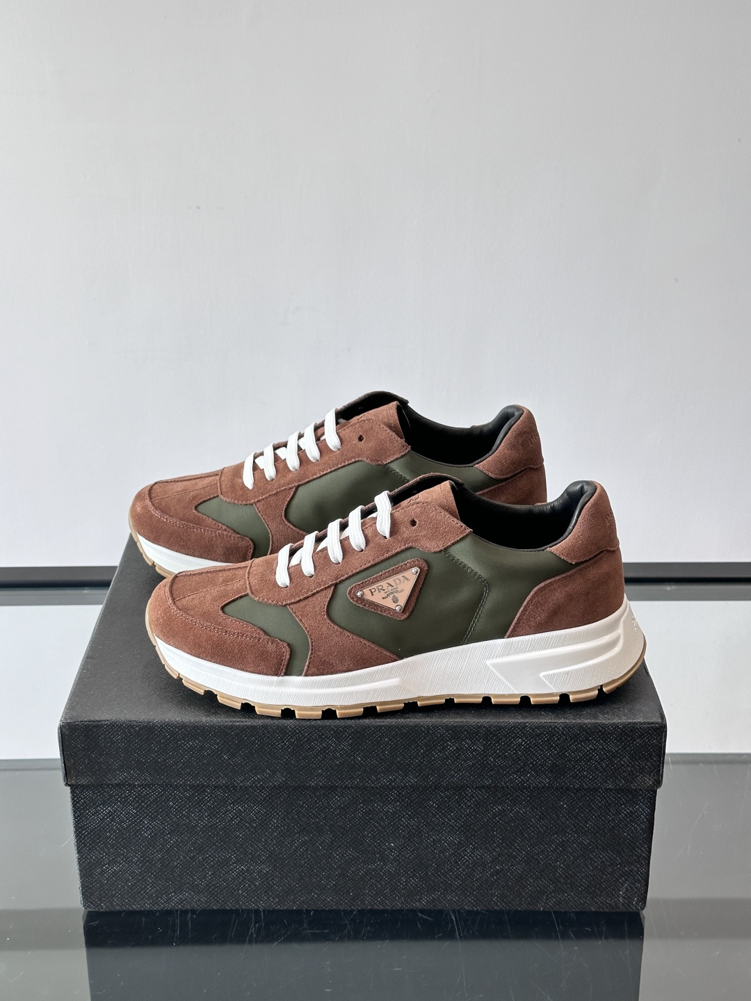 Prada 男士休闲运动鞋。采用麂皮与尼龙面料拼接，质感柔软又耐用，低调奢华。鞋侧三角徽标超有辨识度，橡