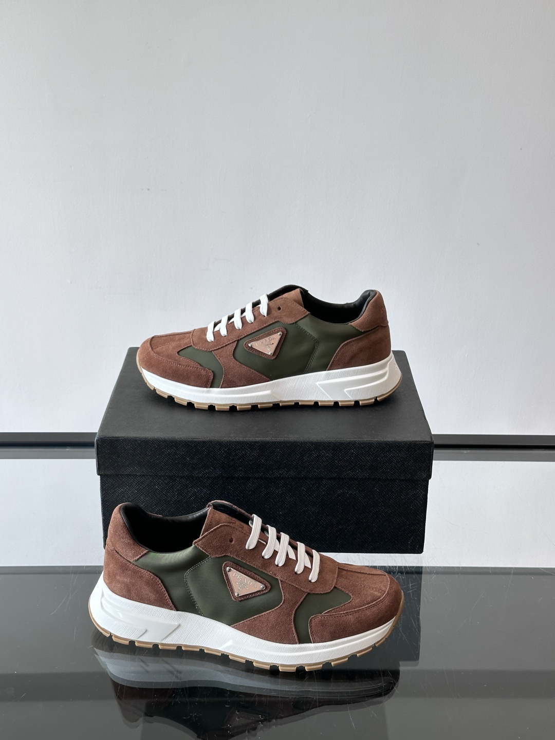 Prada 男士休闲运动鞋。采用麂皮与尼龙面料拼接，质感柔软又耐用，低调奢华。鞋侧三角徽标超有辨识度，橡