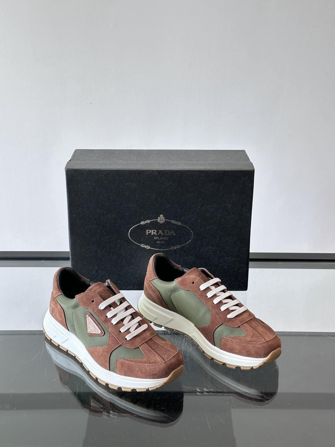 Prada 男士休闲运动鞋。采用麂皮与尼龙面料拼接，质感柔软又耐用，低调奢华。鞋侧三角徽标超有辨识度，橡
