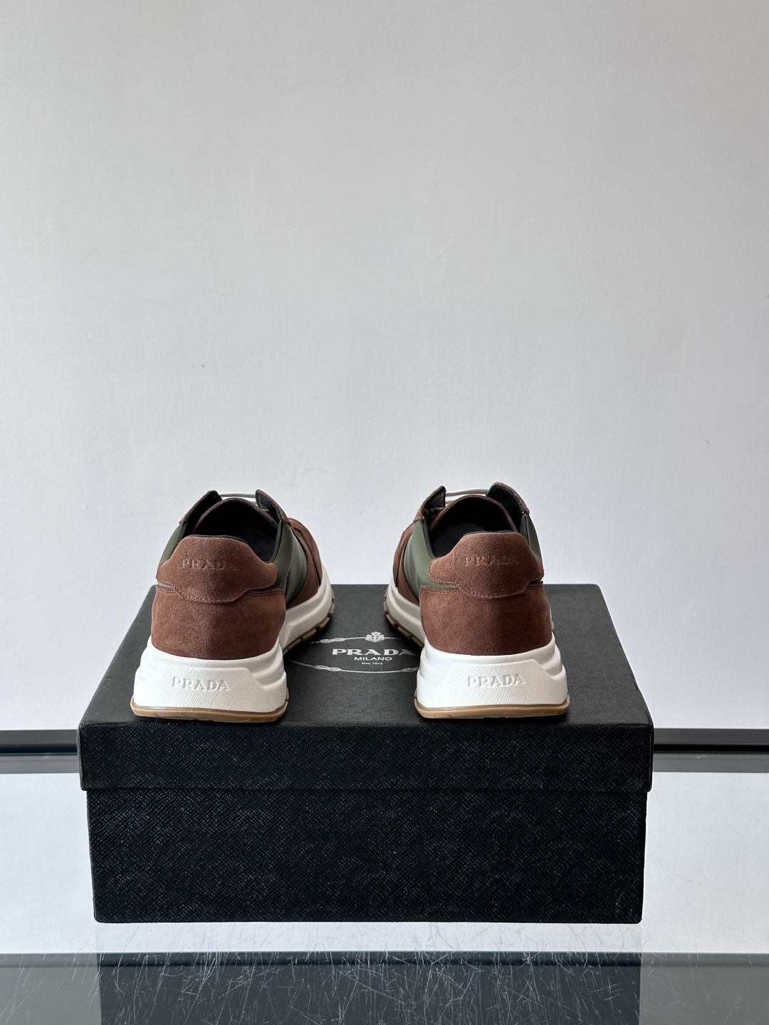 Prada 男士休闲运动鞋。采用麂皮与尼龙面料拼接，质感柔软又耐用，低调奢华。鞋侧三角徽标超有辨识度，橡