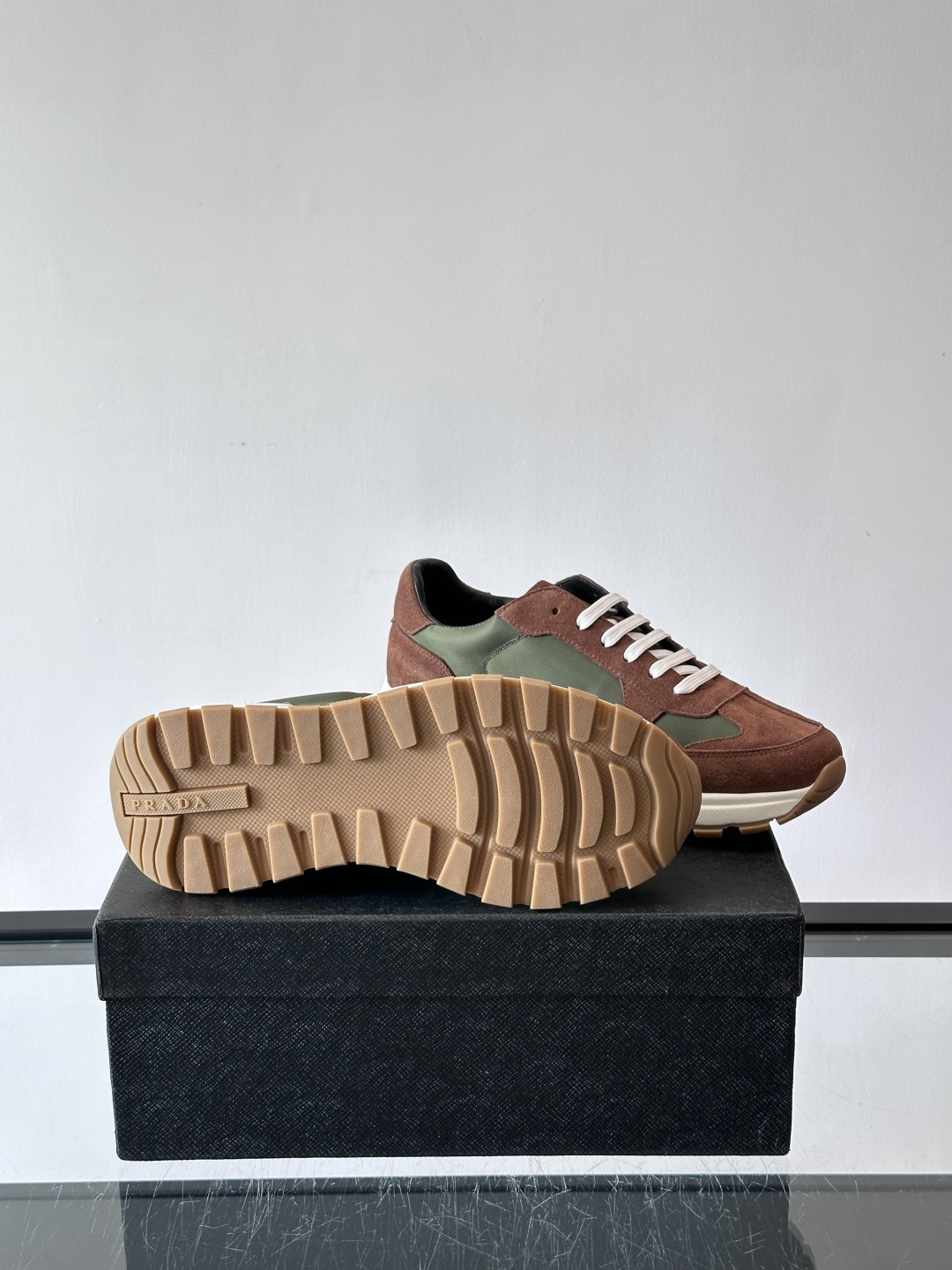 Prada 男士休闲运动鞋。采用麂皮与尼龙面料拼接，质感柔软又耐用，低调奢华。鞋侧三角徽标超有辨识度，橡