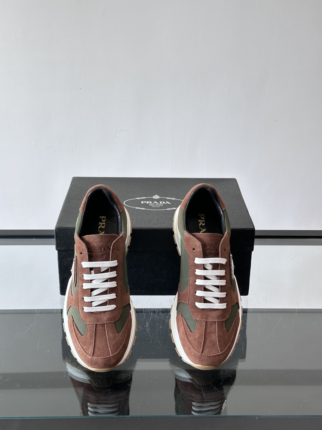 Prada 男士休闲运动鞋。采用麂皮与尼龙面料拼接，质感柔软又耐用，低调奢华。鞋侧三角徽标超有辨识度，橡