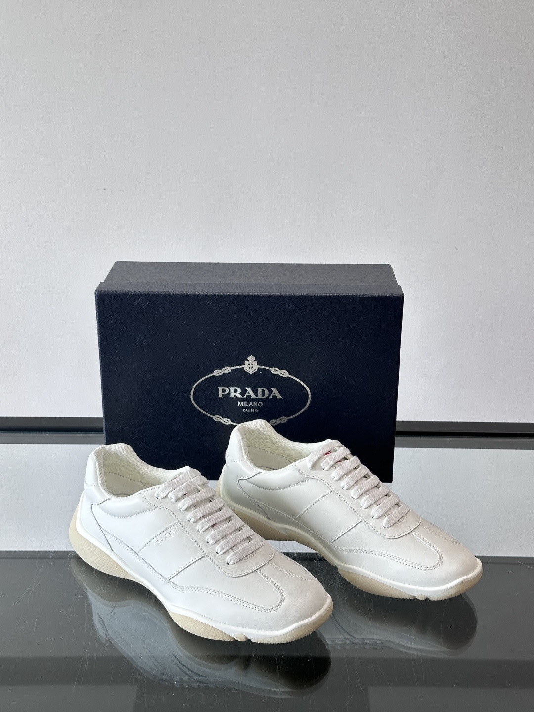 Prada 男士牛革运动鞋选用优质牛皮，鞋面光滑细腻，简约设计中融入品牌徽标，辨识度满分。橡胶鞋底轻便耐