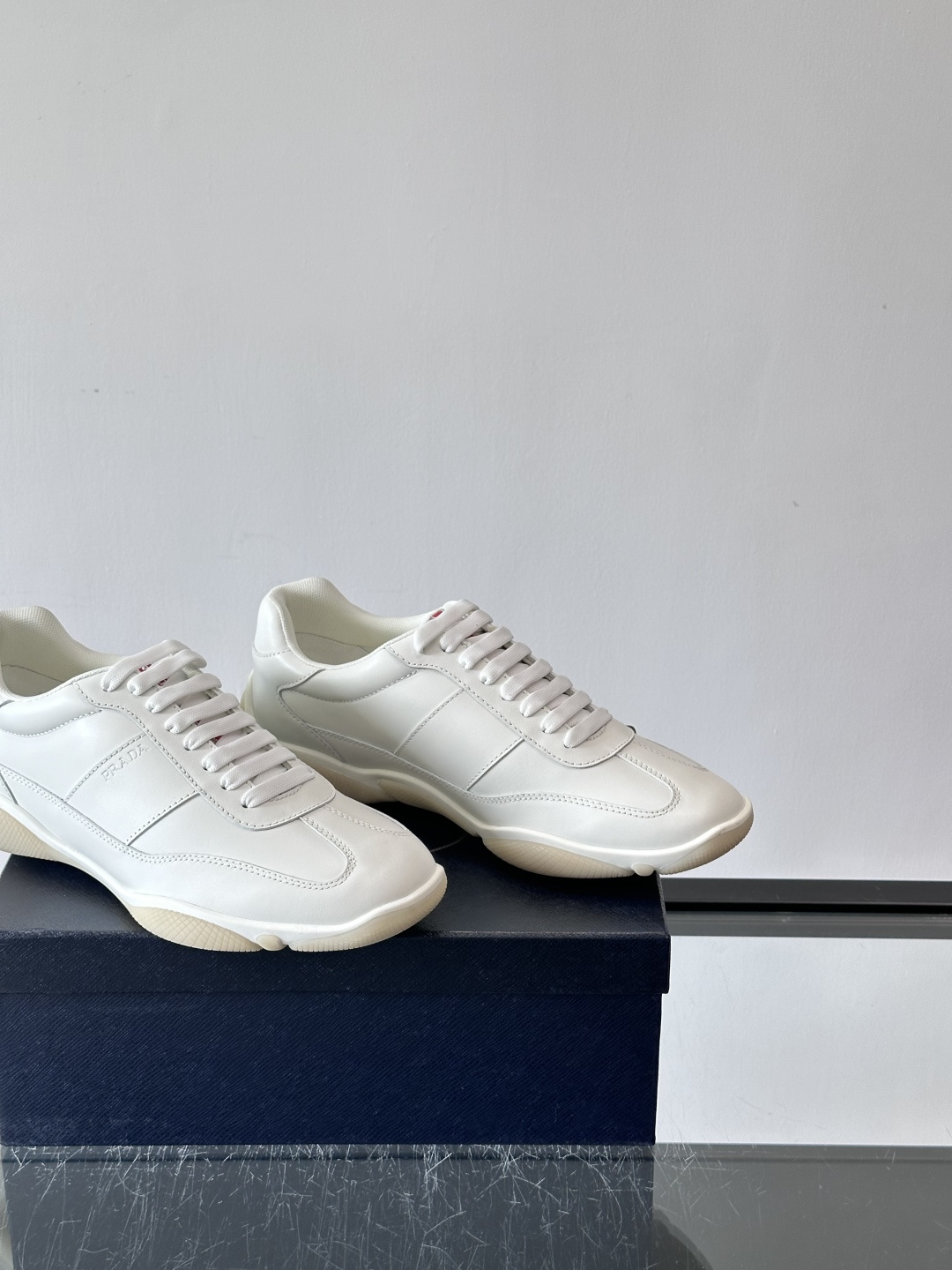 Prada 男士牛革运动鞋选用优质牛皮，鞋面光滑细腻，简约设计中融入品牌徽标，辨识度满分。橡胶鞋底轻便耐