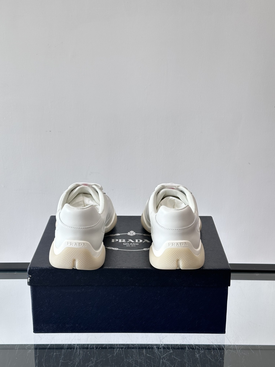 Prada 男士牛革运动鞋选用优质牛皮，鞋面光滑细腻，简约设计中融入品牌徽标，辨识度满分。橡胶鞋底轻便耐