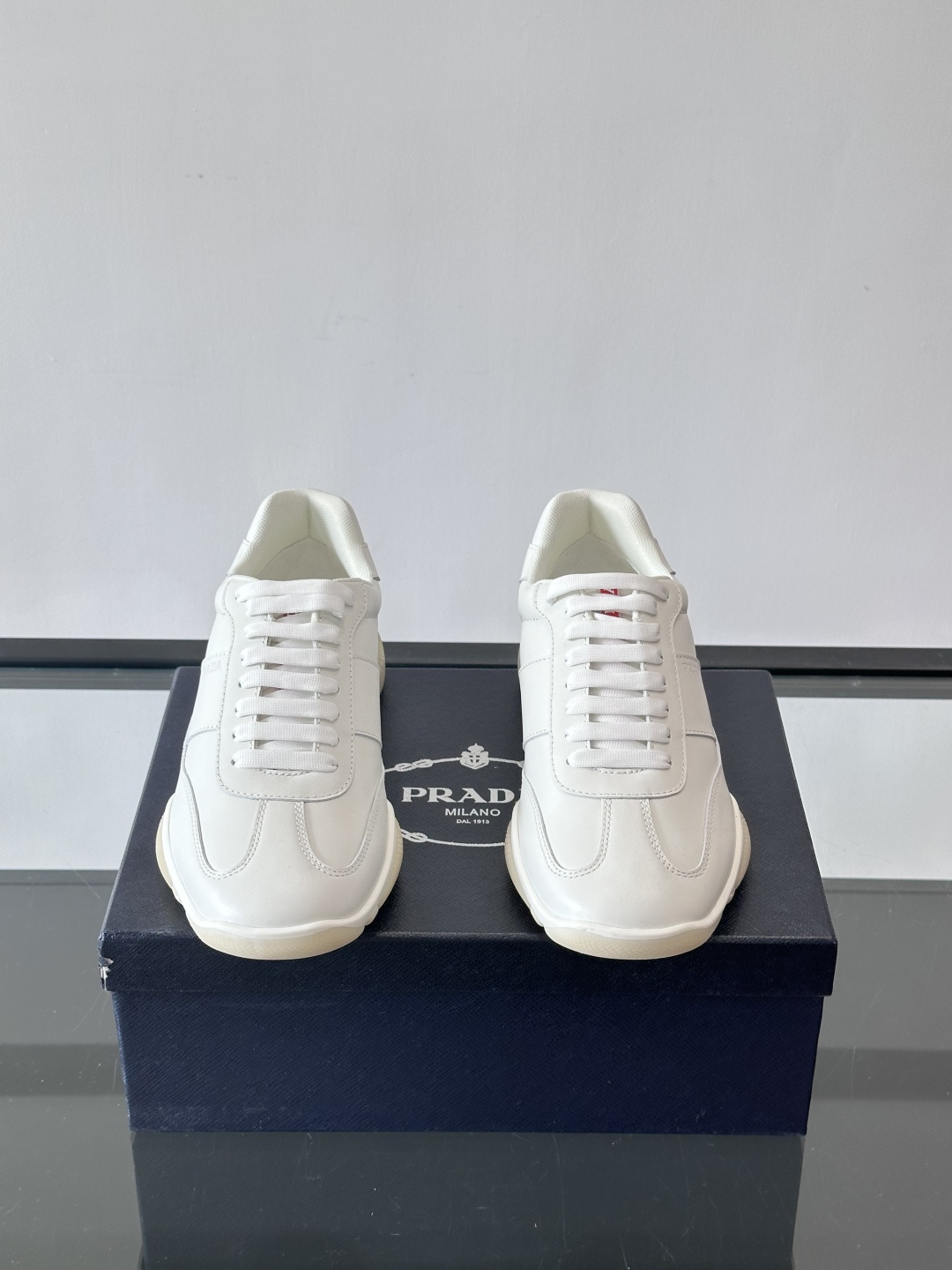 Prada 男士牛革运动鞋选用优质牛皮，鞋面光滑细腻，简约设计中融入品牌徽标，辨识度满分。橡胶鞋底轻便耐