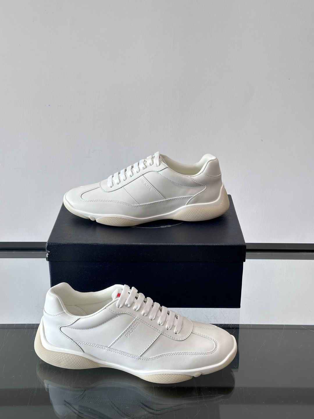 Prada 男士牛革运动鞋选用优质牛皮，鞋面光滑细腻，简约设计中融入品牌徽标，辨识度满分。橡胶鞋底轻便耐