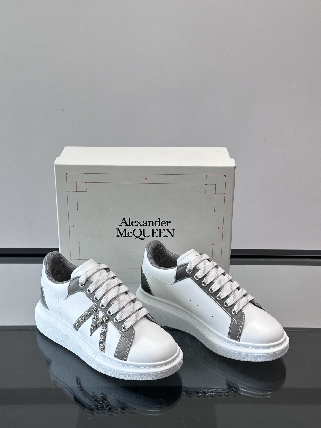 Alexander McQueen厚底休闲鞋，白色牛皮革鞋面+灰色拼接，简约又有层次感。鞋侧金属铆钉点缀