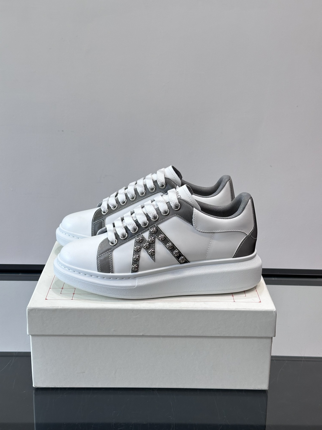 Alexander McQueen厚底休闲鞋，白色牛皮革鞋面+灰色拼接，简约又有层次感。鞋侧金属铆钉点缀
