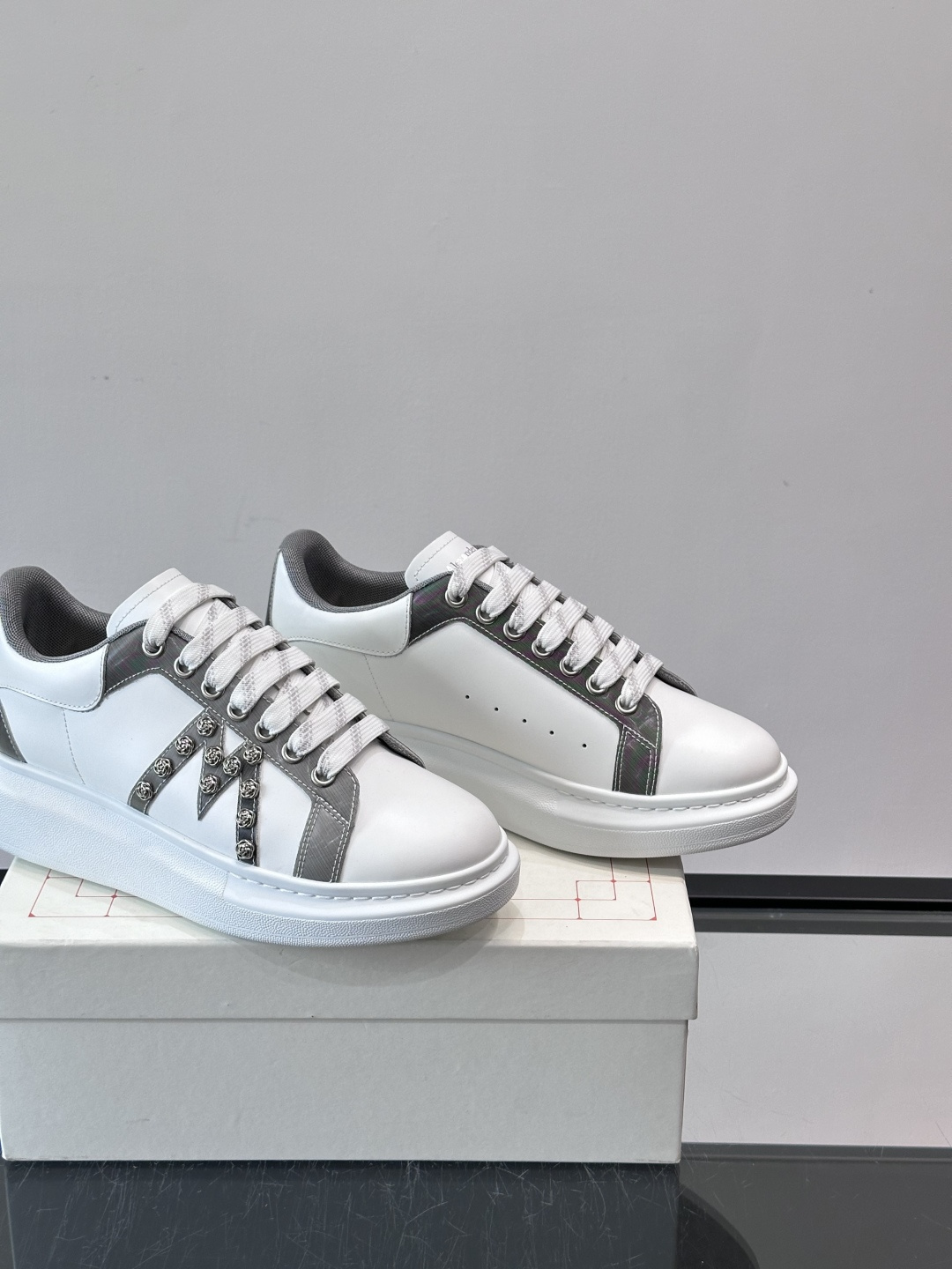 Alexander McQueen厚底休闲鞋，白色牛皮革鞋面+灰色拼接，简约又有层次感。鞋侧金属铆钉点缀
