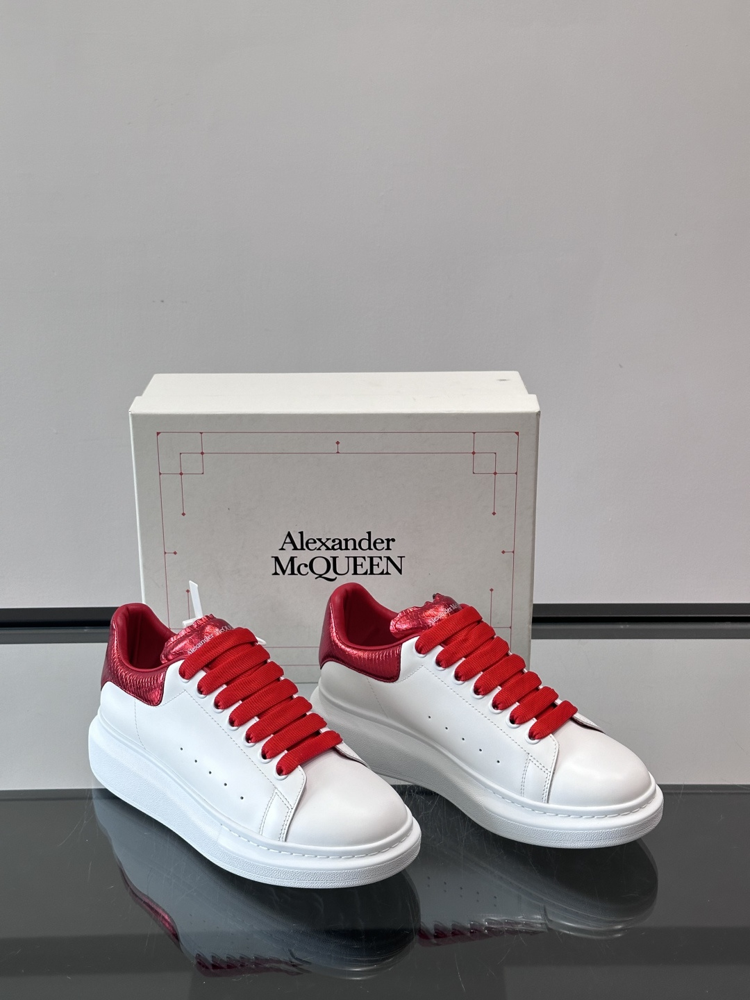 Alexander McQueen 红尾小白鞋采用白色牛皮革鞋面+红色蛇皮纹理后跟，搭配同色鞋带，视觉超