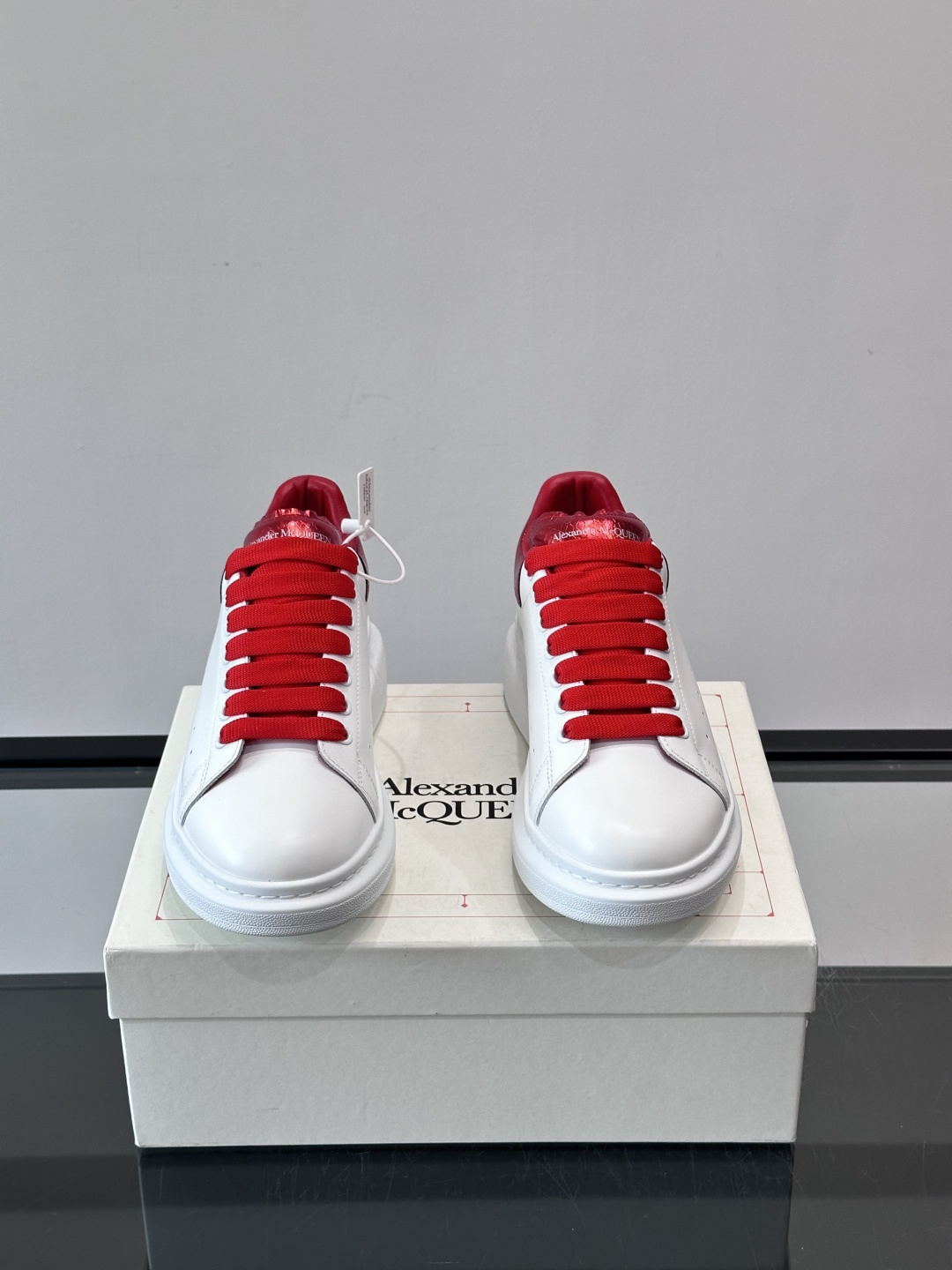 Alexander McQueen 红尾小白鞋采用白色牛皮革鞋面+红色蛇皮纹理后跟，搭配同色鞋带，视觉超