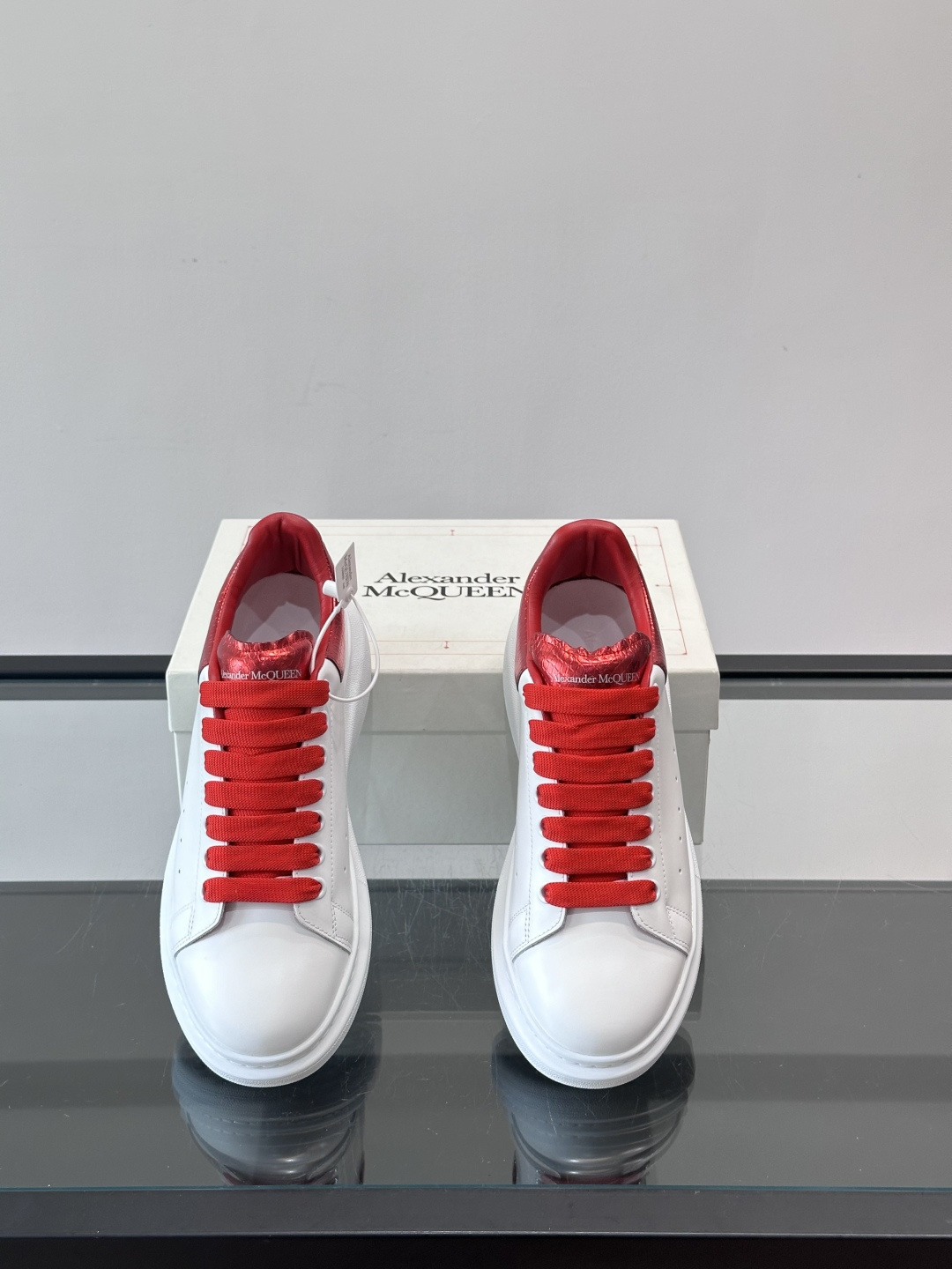 Alexander McQueen 红尾小白鞋采用白色牛皮革鞋面+红色蛇皮纹理后跟，搭配同色鞋带，视觉超