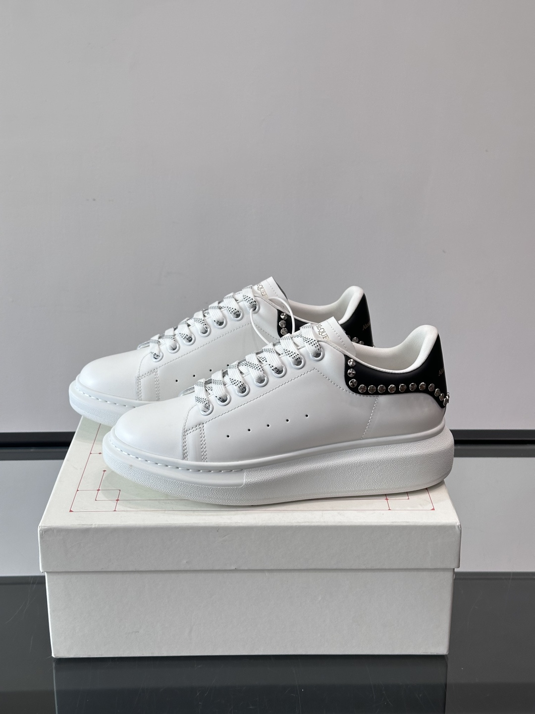 Alexander McQueen厚底休闲鞋，白色牛皮革鞋面+黑色拼接，简约又有层次感。鞋侧金属铆钉点缀