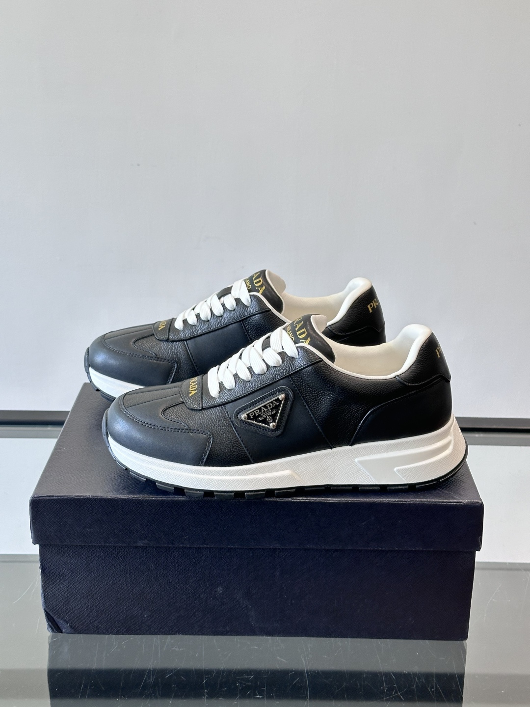 Prada这款运动鞋采用优质牛皮革，鞋面简约流畅，搭配经典三角Logo，低调又有辨识度。厚底设计，穿着舒