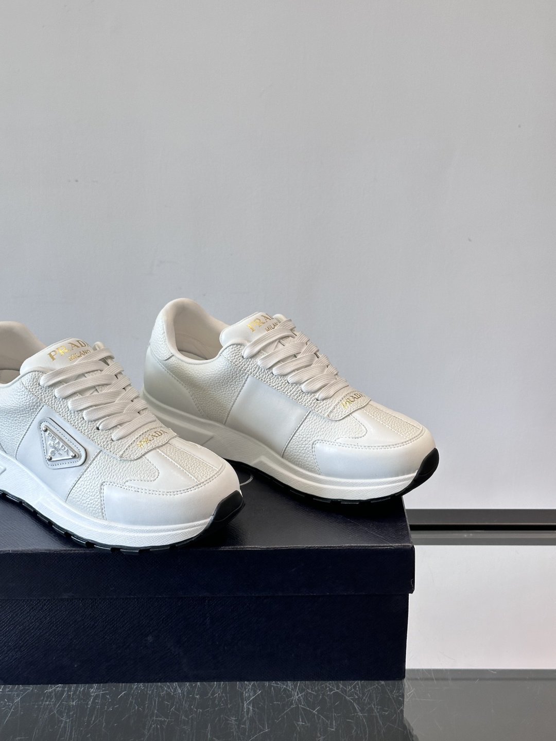 Prada这款运动鞋采用优质牛皮革，鞋面简约流畅，搭配经典三角Logo，低调又有辨识度。厚底设计，穿着舒