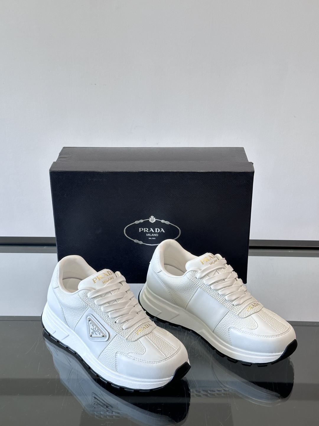 Prada这款运动鞋采用优质牛皮革，鞋面简约流畅，搭配经典三角Logo，低调又有辨识度。厚底设计，穿着舒
