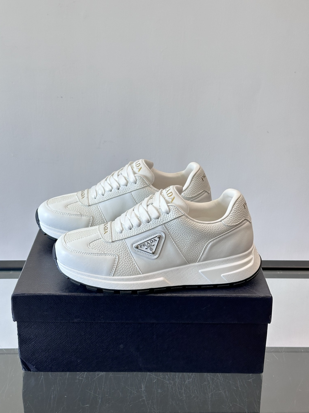 Prada这款运动鞋采用优质牛皮革，鞋面简约流畅，搭配经典三角Logo，低调又有辨识度。厚底设计，穿着舒