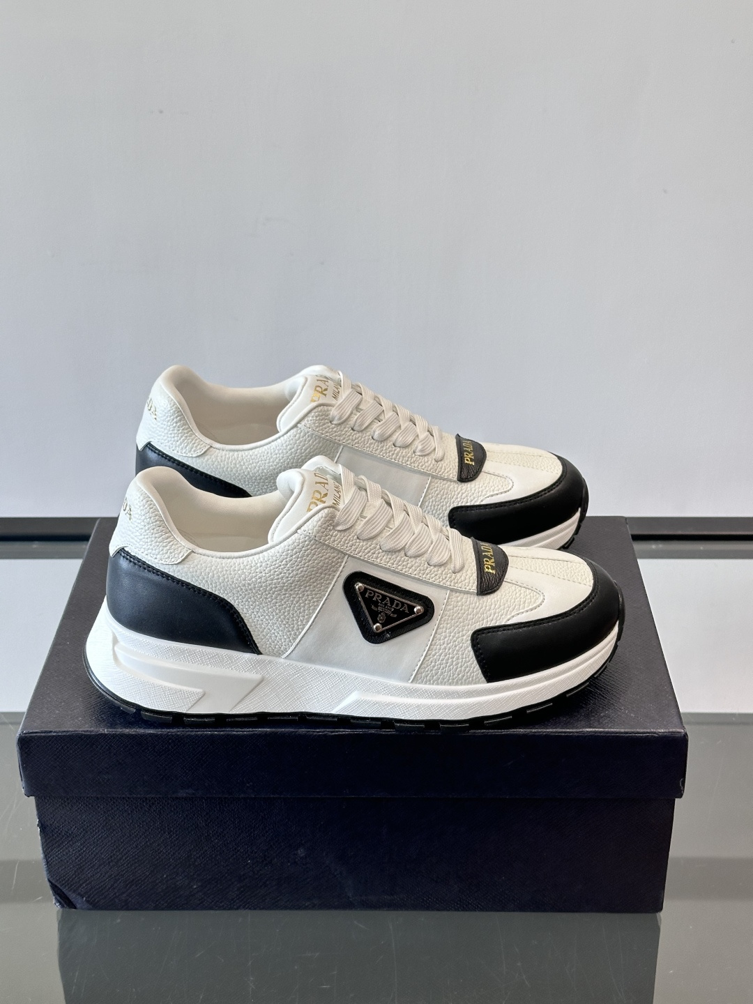 Prada这款运动鞋采用优质牛皮革，鞋面简约流畅，搭配经典三角Logo，低调又有辨识度。厚底设计，穿着舒