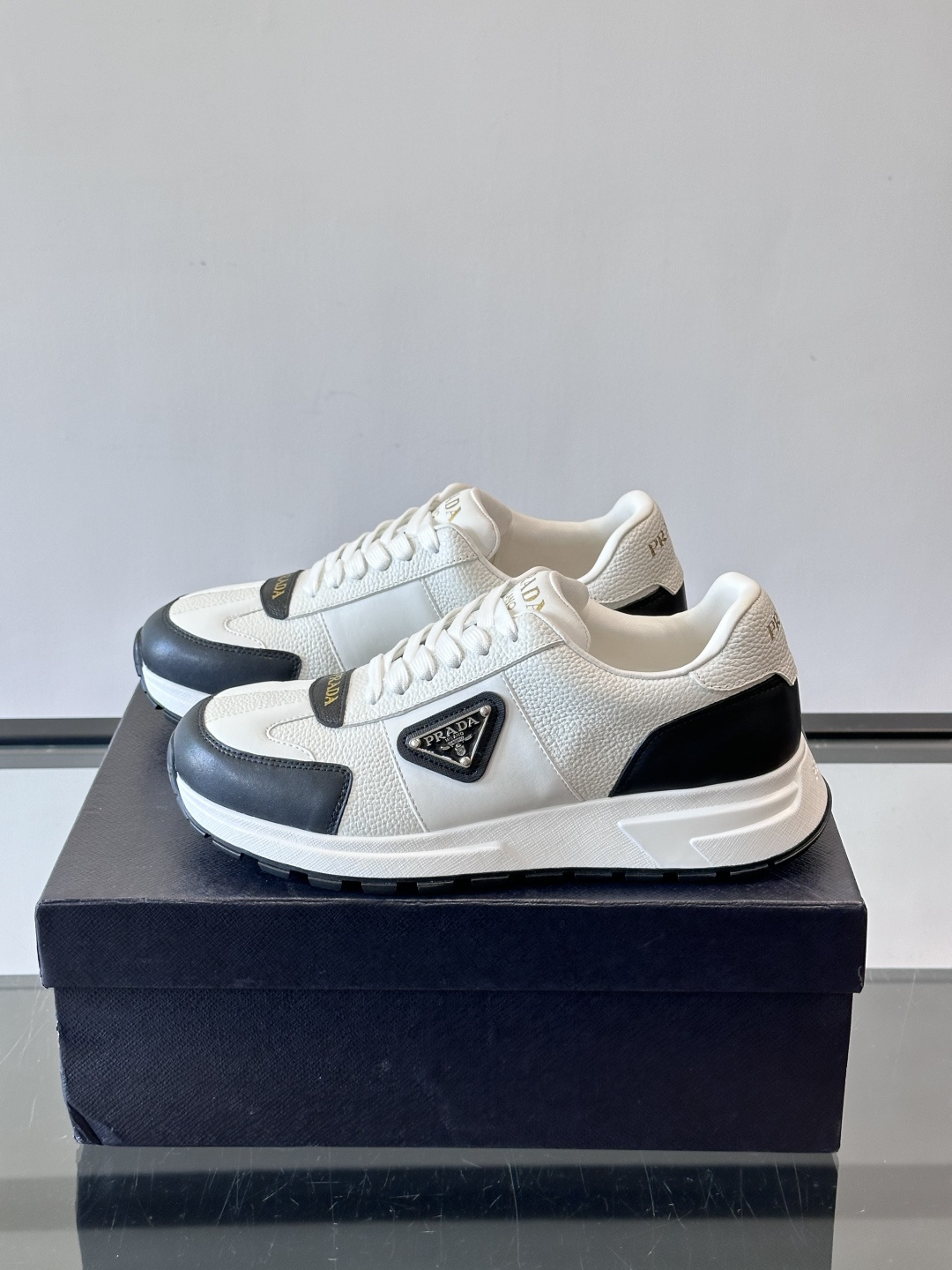Prada这款运动鞋采用优质牛皮革，鞋面简约流畅，搭配经典三角Logo，低调又有辨识度。厚底设计，穿着舒
