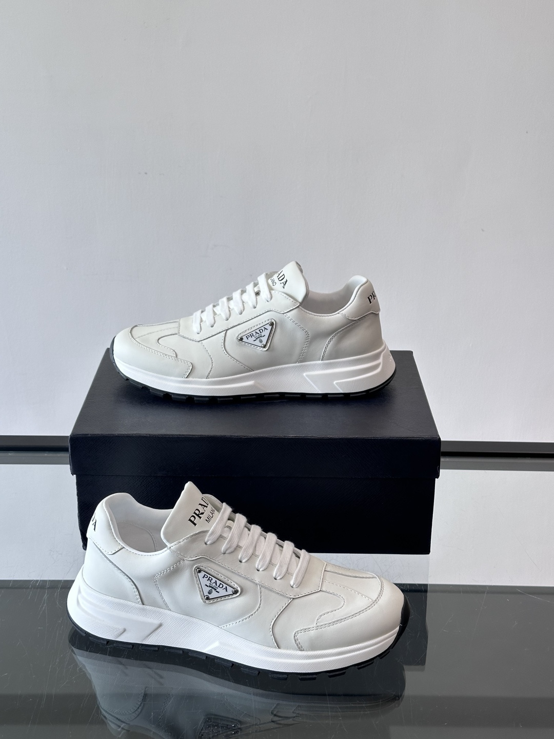 Prada这款运动鞋采用优质牛皮革，鞋面简约流畅，搭配经典三角Logo，低调又有辨识度。厚底设计，穿着舒