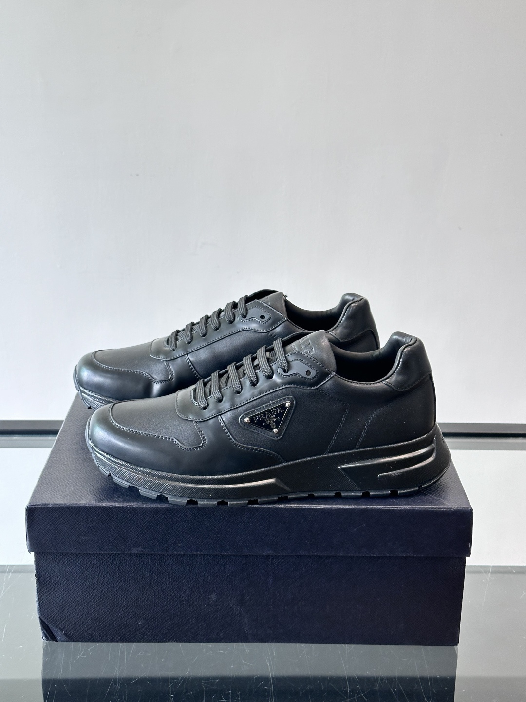 Prada这款运动鞋采用优质牛皮革，鞋面简约流畅，搭配经典三角Logo，低调又有辨识度。厚底设计，穿着舒