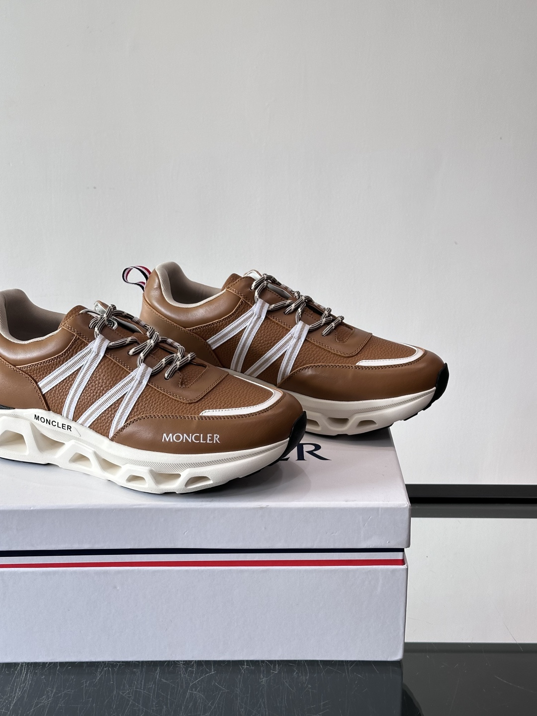 Moncler这款男士运动鞋，采用优质牛皮革，透气又有质感。条纹和品牌标识超有辨识度，厚底设计穿着舒适还