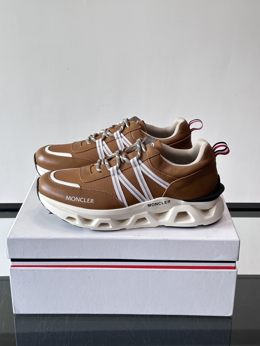 Moncler这款男士运动鞋，采用优质牛皮革，透气又有质感。条纹和品牌标识超有辨识度，厚底设计穿着舒适还