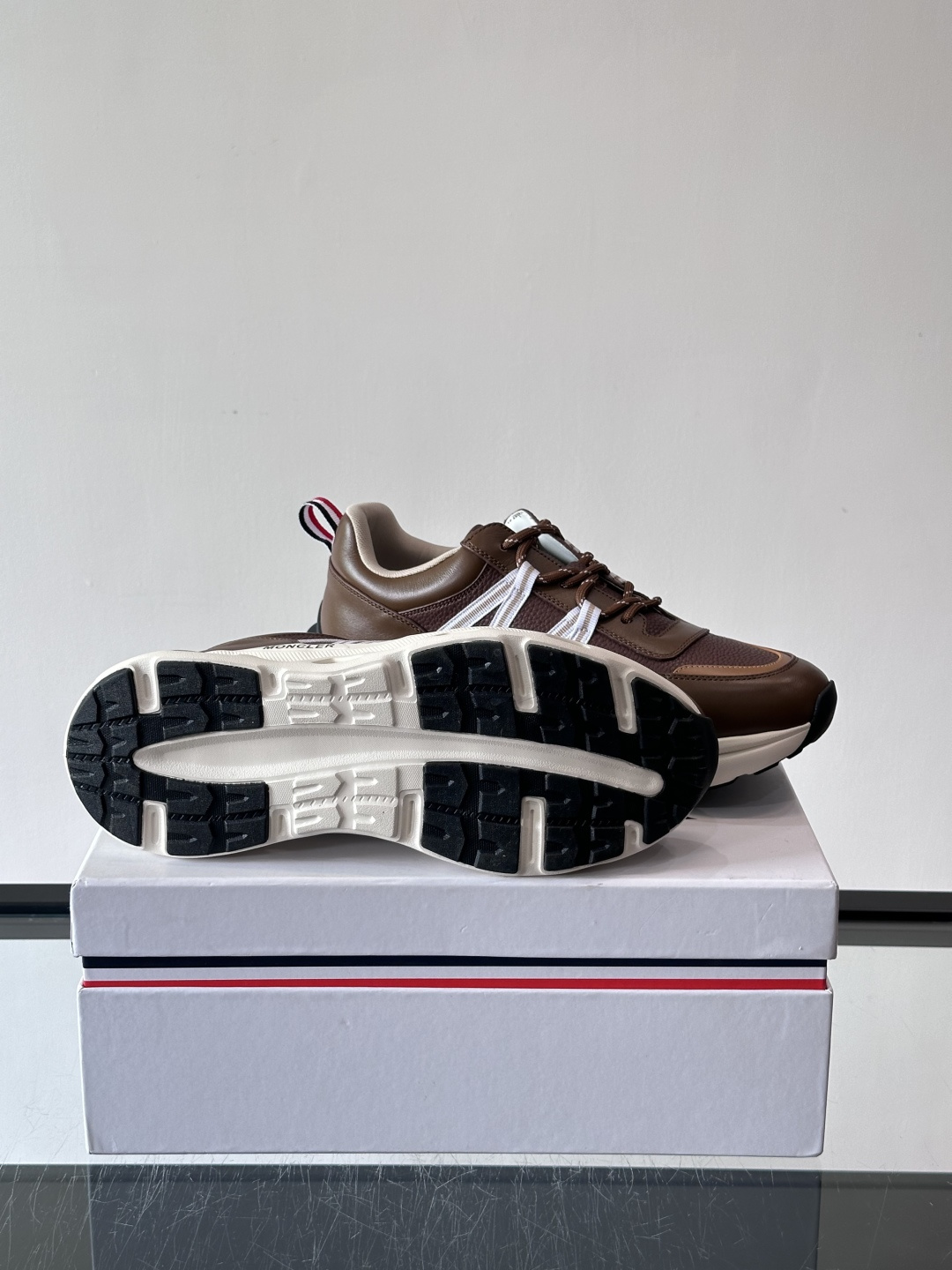 Moncler这款男士运动鞋，采用优质牛皮革，透气又有质感。条纹和品牌标识超有辨识度，厚底设计穿着舒适还