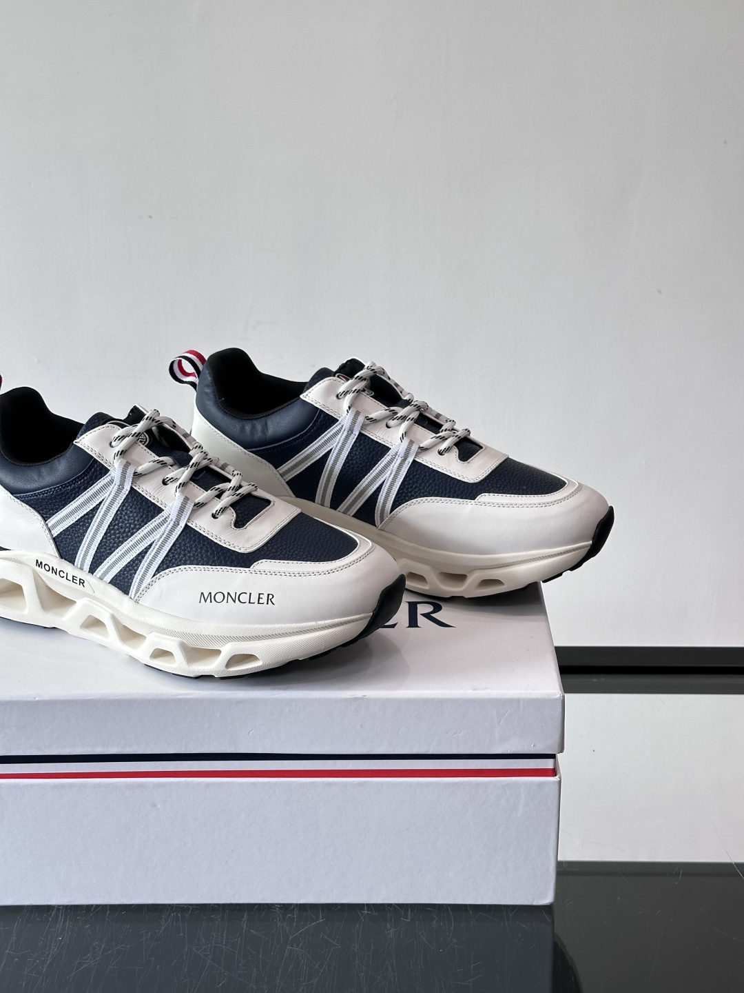 Moncler这款男士运动鞋，采用优质牛皮革，透气又有质感。条纹和品牌标识超有辨识度，厚底设计穿着舒适还