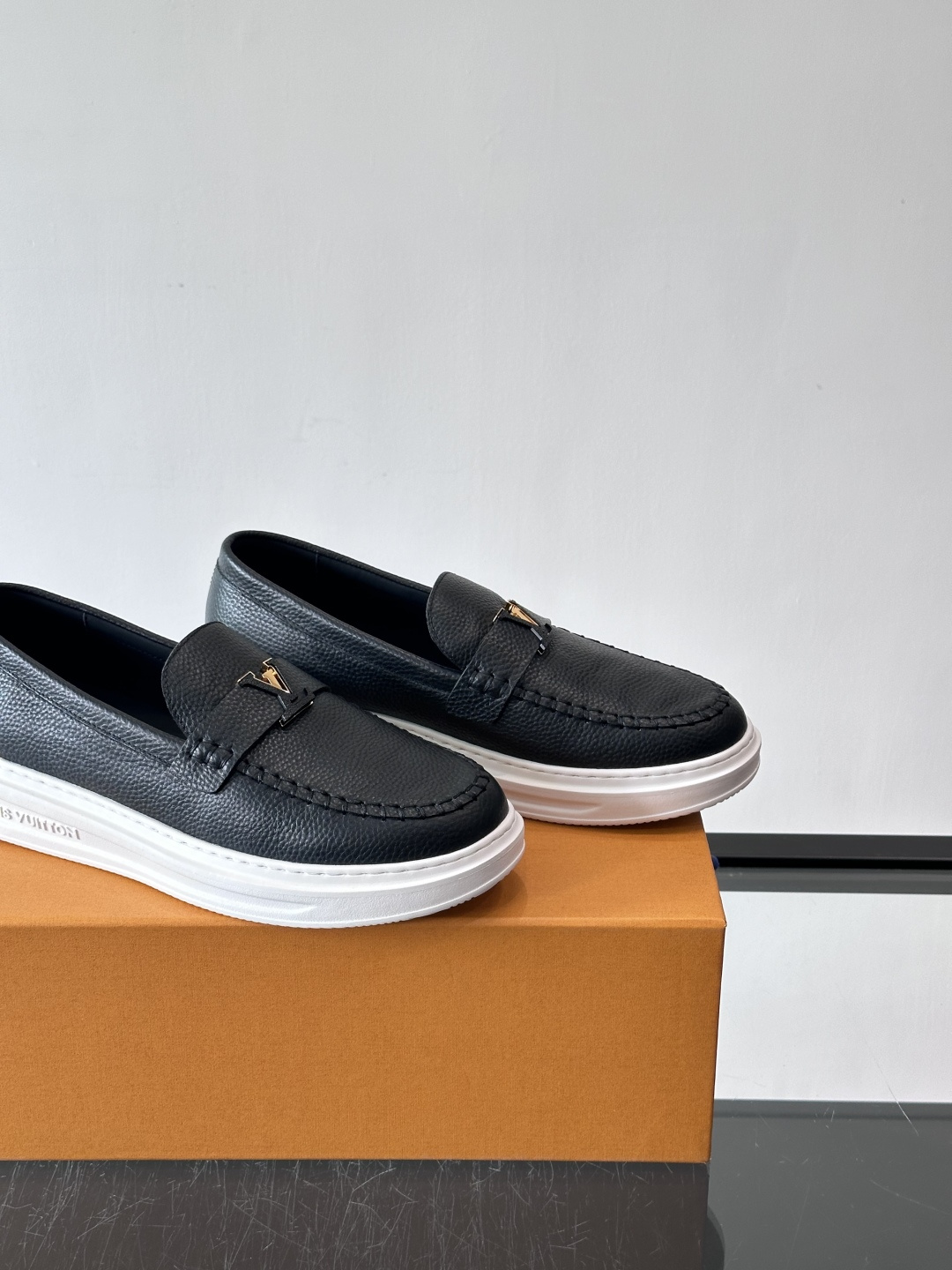 L.V Estate男士经典休闲乐福鞋，取材柔软牛皮革制成，营造休闲舒适体验。饰带点缀 LV 字母装饰，