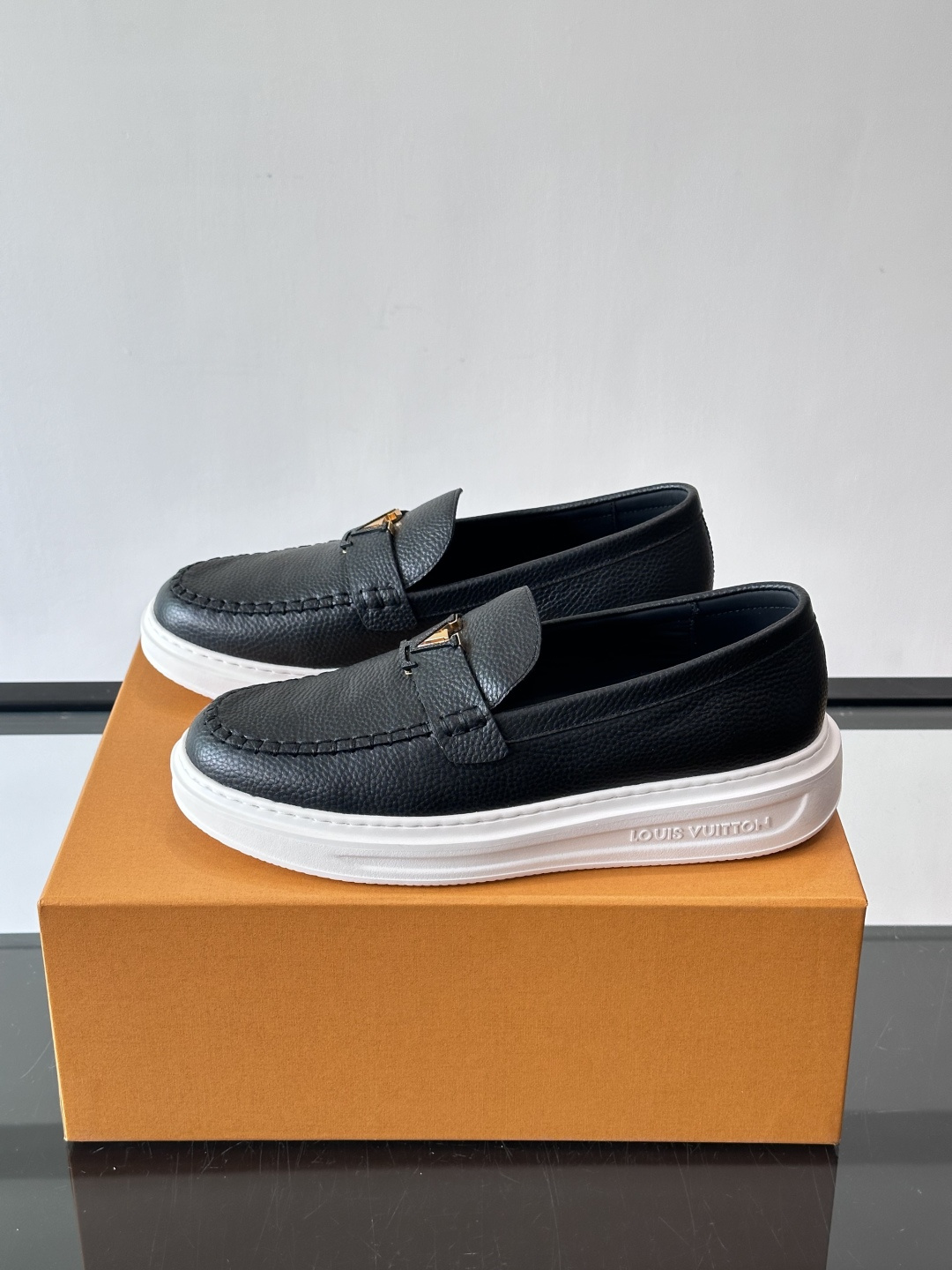 L.V Estate男士经典休闲乐福鞋，取材柔软牛皮革制成，营造休闲舒适体验。饰带点缀 LV 字母装饰，