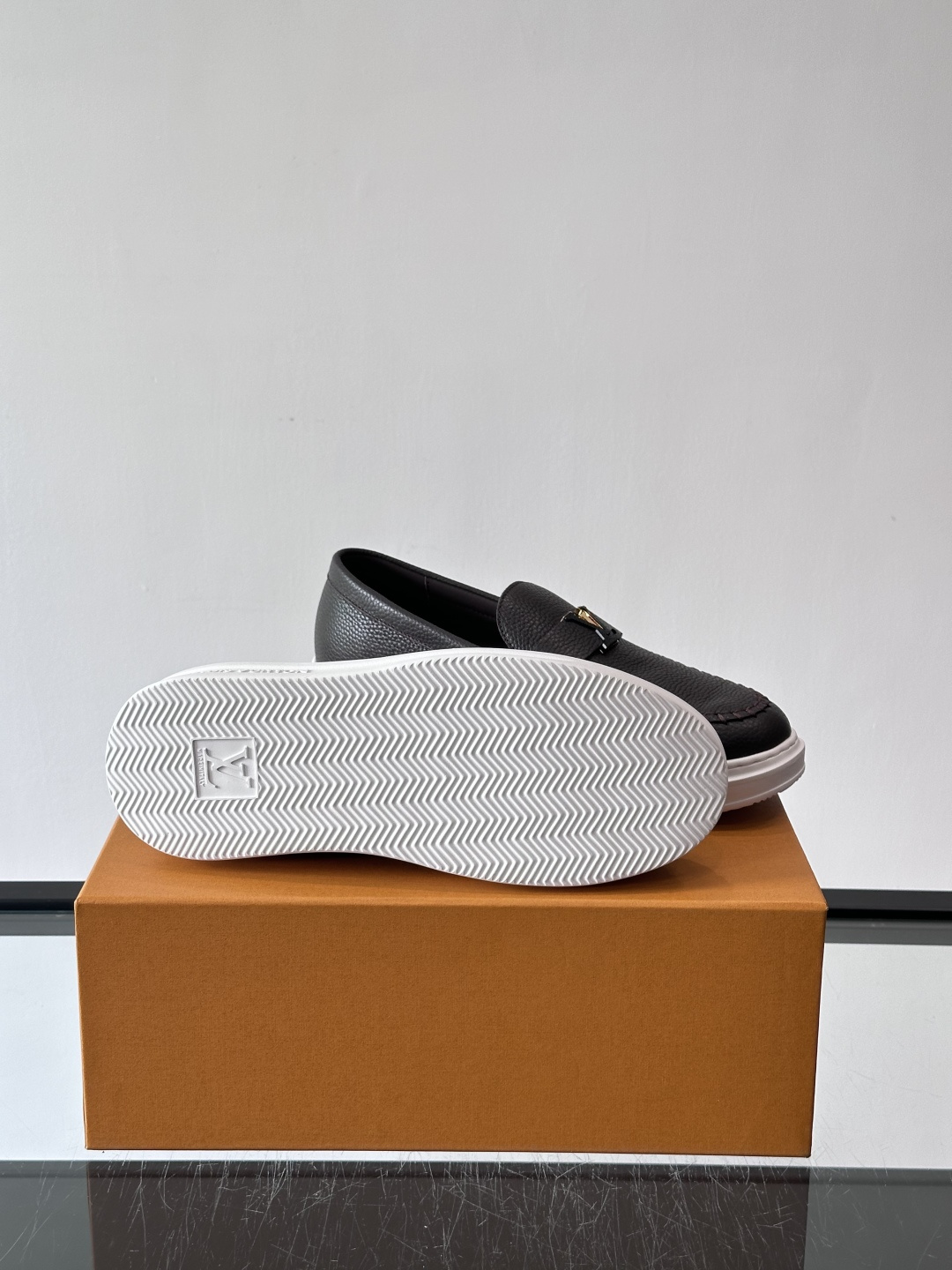 L.V Estate男士经典休闲乐福鞋，取材柔软牛皮革制成，营造休闲舒适体验。饰带点缀 LV 字母装饰，